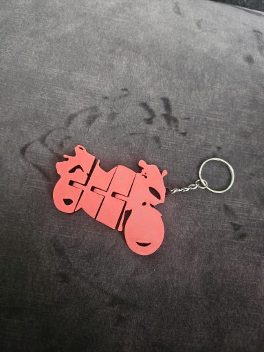Rode sleutelhanger in de vorm van een motorfiets.